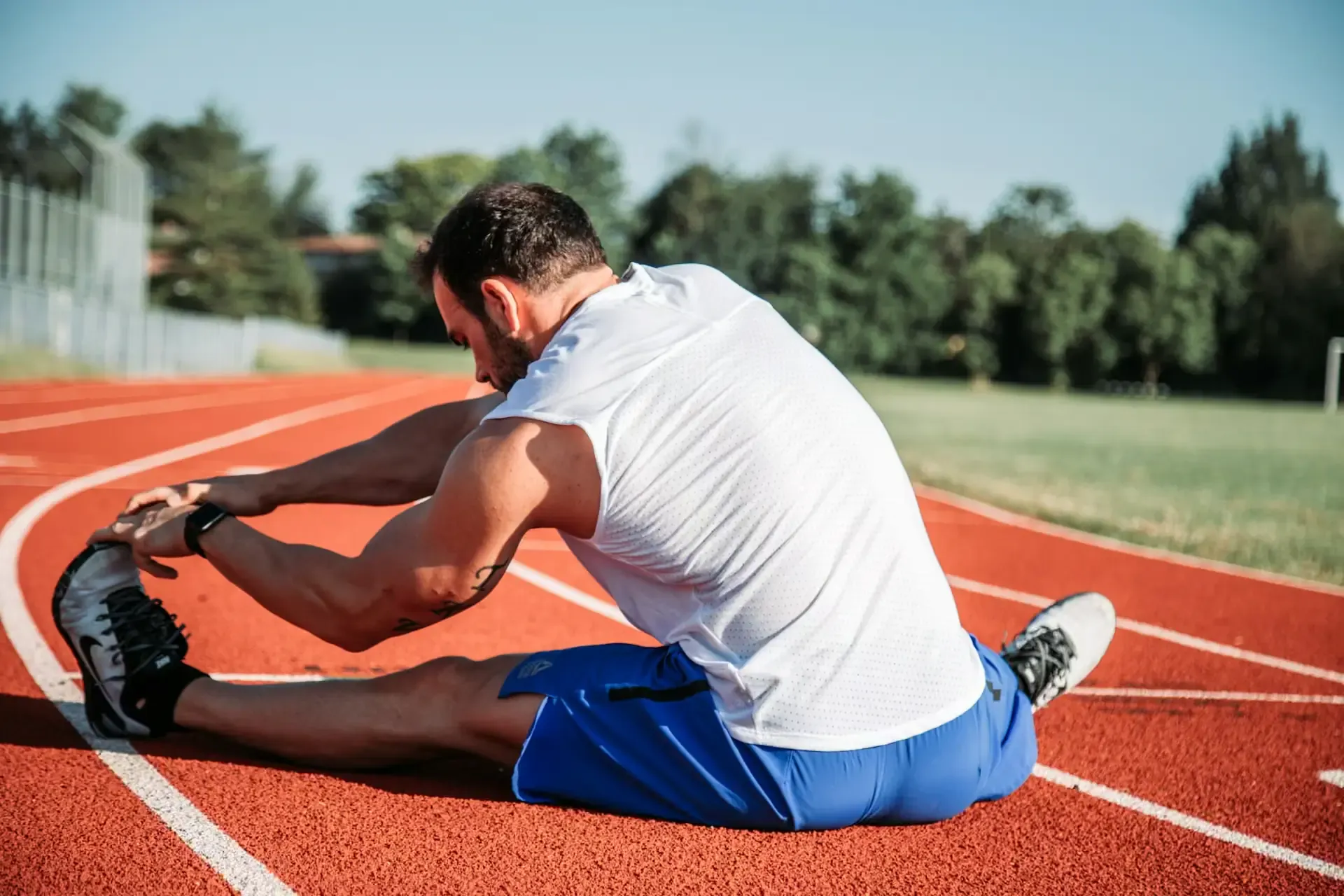 Man stretching on track