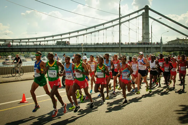 marathon runners and bridge in background