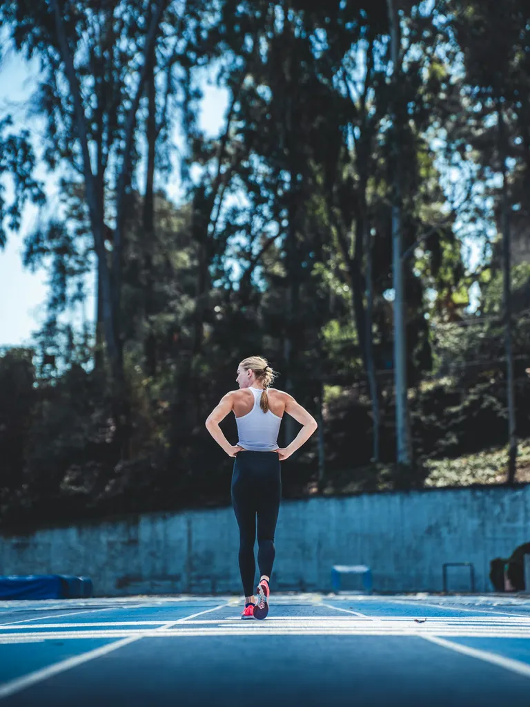Woman resting during track workout.